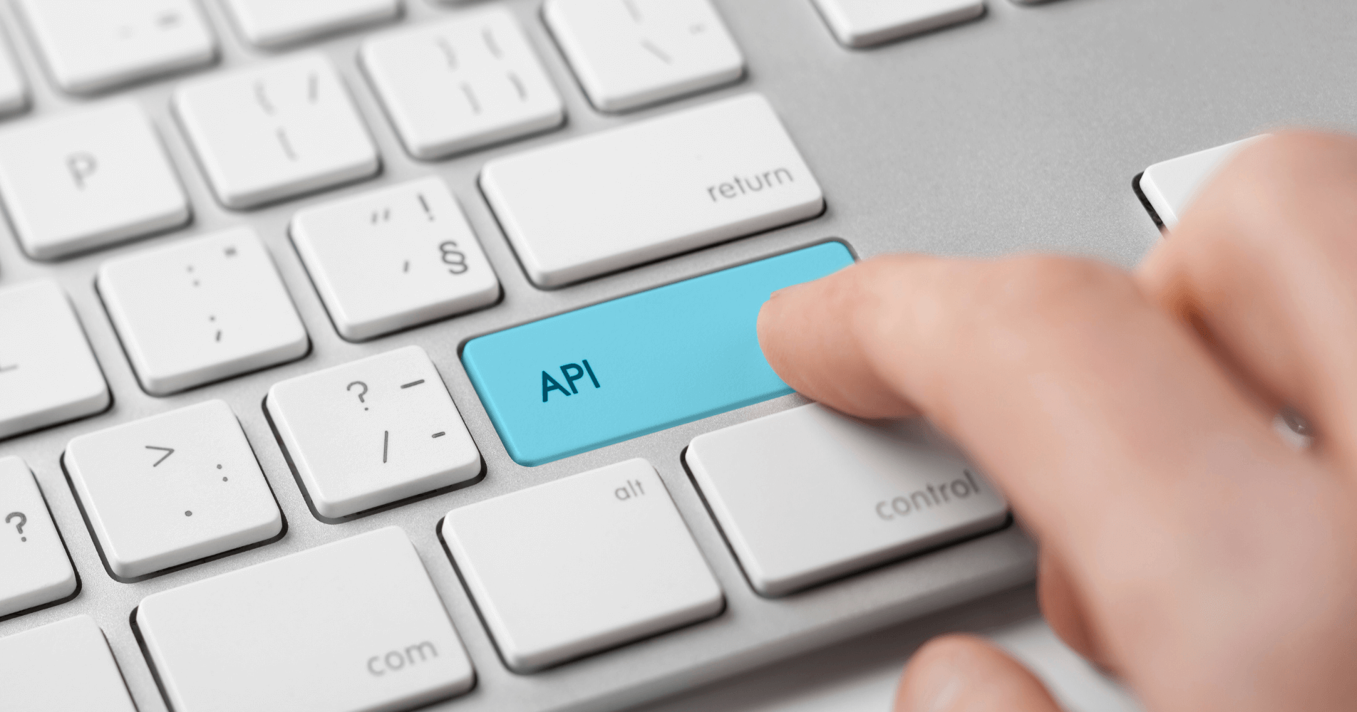 A hand hovers over a keyboard with a key labelled API