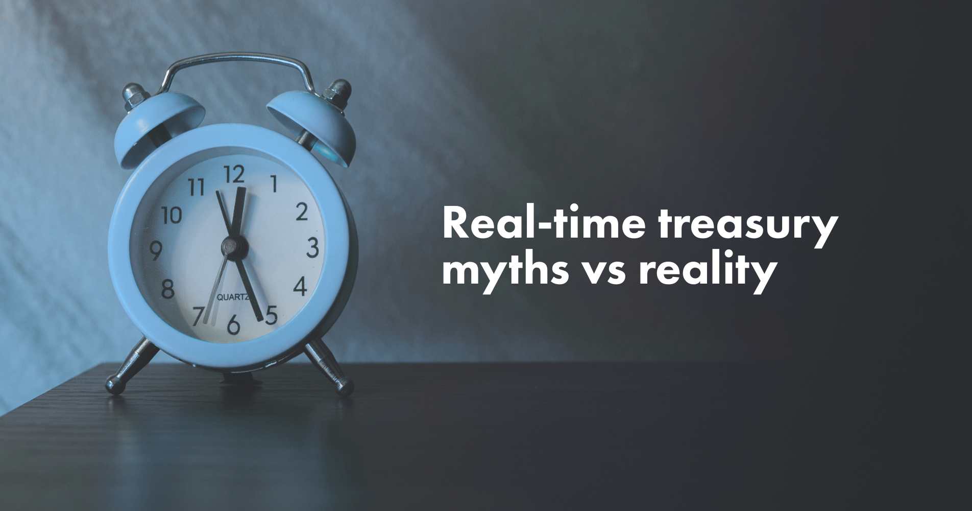 An alarm clock on a table with the words "real-time treasury myths vs reality"